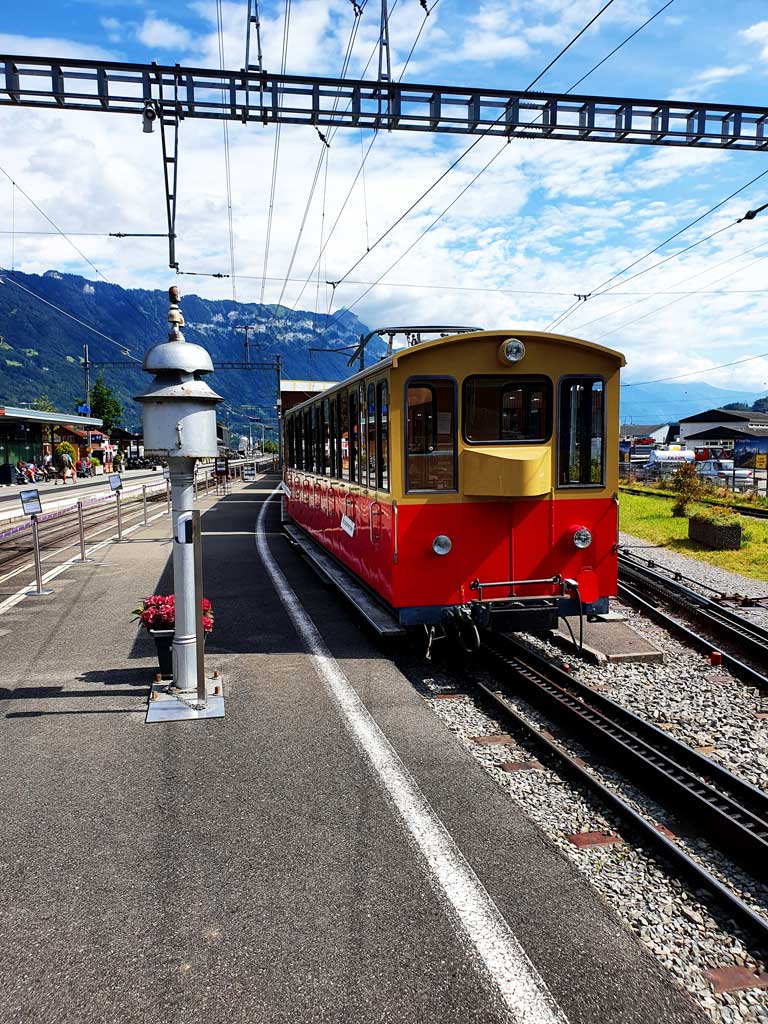 Rot, gelber, historischer Bahnwaggon der Schynigen Platte Bahn