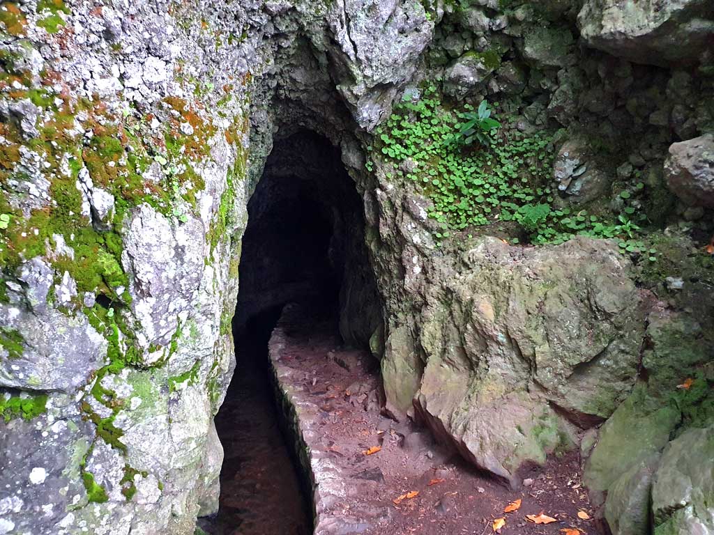 Madeira Reisetipps: Packt eine Taschen- oder Stirnlampe ein. Niedriger Tunnel, der in die Felswand geschlagen wurde.