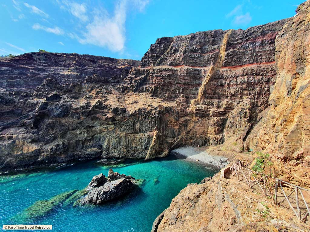 Porto Santo Sehenswürdigkeiten: Imposante, vulkanisch geprägte Steilklippen umgeben den steinigen Strand Praia do Zombralinho mit klarem Wasser