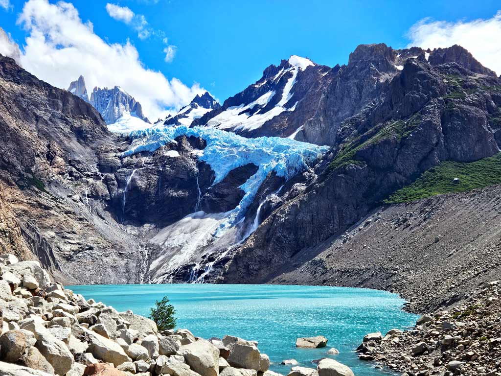 Hellblauer Gletschersee Laguna Piedras Blancas mit dem überhängenden Gletscher vor einer eindrücklichen Bergkulisse die zu den schönsten Patagonien Sehenswürdigkeiten zählt