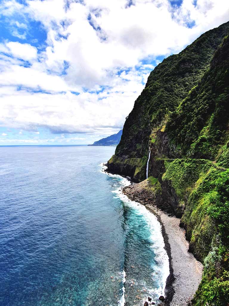 Porto Moniz Madeira Sehenswürdigkeiten: Véu da Novia Wasserfall ergiesst sich über die grüne Klippe in den Atlantik auf Madeira