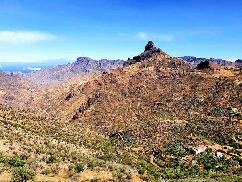 Gelb leuchtende Schlucht am Fusse des Roque Bentaygas in der nähe von Tejeda im Sommer mit der Nachbarinsel Teneriffa im Hintergrund