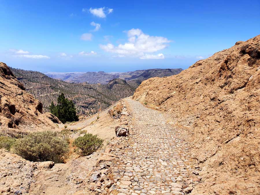 Gran Canaria wandern Pico de las Nieves Wanderung: Ausblick über den Naturpark Pilancones auf dem historischen Weg Camino de la Plata mit Pflastersteinen