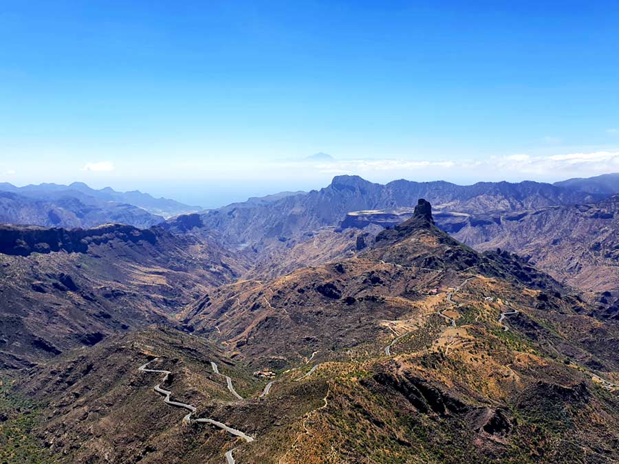 Gran Canaria wandern Roque Nublo Wanderung: Ausblick über die zahlreichen, verwinkelten Schluchten der Caldera de Tejeda mit dem markanten Roque Bentayga im Sommer