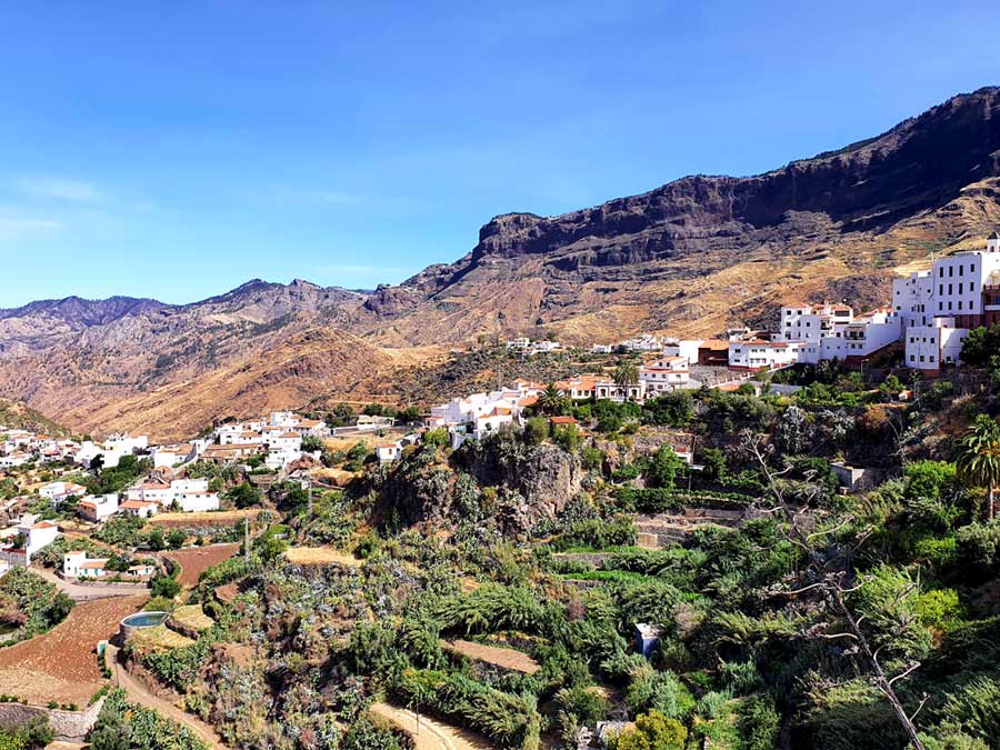 Ausblick auf Tejeda auf Gran Canaria mit weissen Häusern, roten Ziegeldächern und den hohen Bergen der Caldera de Tejeda im Hintergrund