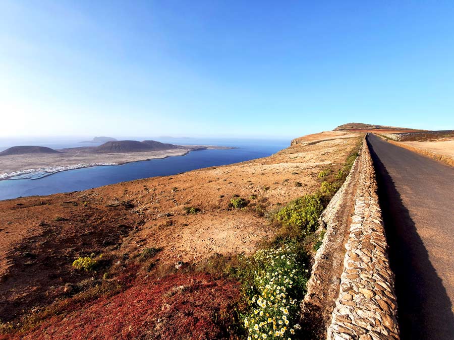 Lanzarote Mietwagen Erfahrungen: Schmale Strasse zum beliebten Aussichtspunkt Mirador del Rio im Nordwesten von Lanzarote mit Ausblick auf die Nachbarinsel La Graciosa