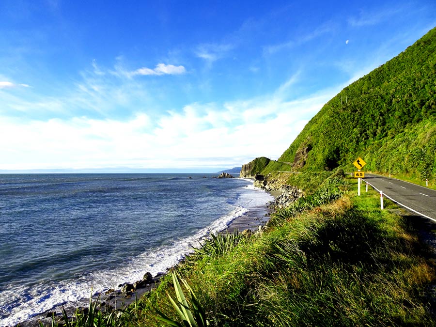 Neuseeland Mietwagen Tipps & Erfahrungen: Schöne Küstenstrasse auf der Südinsel Neuseelands mit grünen Klippen und dunklen Sandstränden