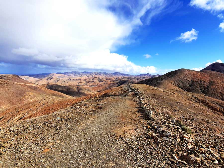 Fuerteventura im Winter Erfahrungen Klima: Inselzentrum mit einer Wolkendecke und Regenschauern in der Ferne