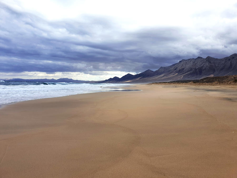 Fuerteventura im Winter Erfahrungen Klima: Langer Sandstrand Playa de Cofete unter einer Wolkendecke