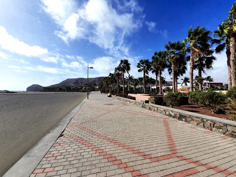 Fuerteventura wo übernachten - Fuerteventura Hotels abseits vom Massentourismus: Mit Palmen gesäumte Küstenpromenade am dunklen Sandstrand