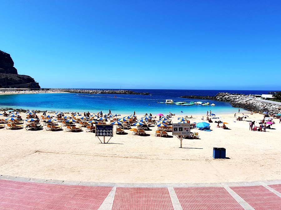 Gran Canaria wo übernachten: heller Sandstrand Playa de Amadores mit zahlreichen Liegestühlen und Sonnenschirmen im Südwesten von Gran Canaria. Hier findet ihr zahlreiche Gran Canaria Hotels.