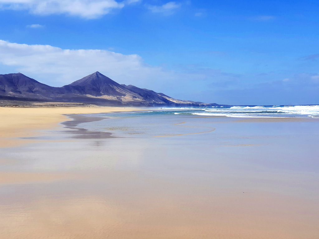 Fuerteventura Aktivitäten und Sehenswürdigkeiten - was tun auf Fuerteventura: Traumhafter Sandstrand Playa de Cofete mit Bergen im Hintergrund