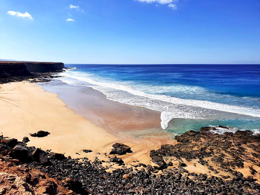 Fuerteventura Aussichtspunkte: Küstenwanderung vor El Cotillo im Nordwesten von Fuerteventura mit Blick auf einen breiten Sandstrand