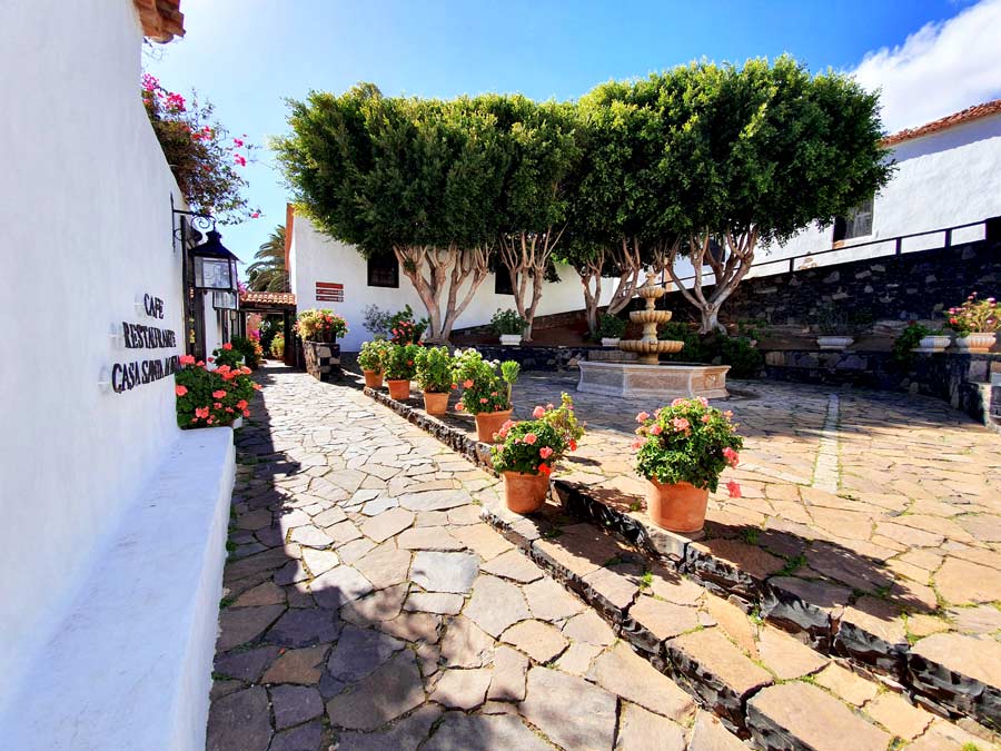 Schönste Orte Fuerteventura abseits des Massentourismus: Dorfplatz mit Brunnen, Bäumen und schönen Blumen in Betancuria, der ehemaligen Hauptstadt von Fuerteventura