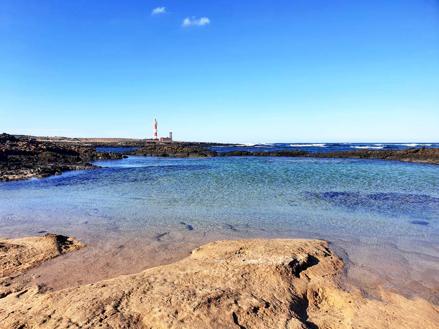 Schönste Orte Fuerteventura El Cotillo: klares Meerwasser mit dem Leuchtturm im Hintergrund